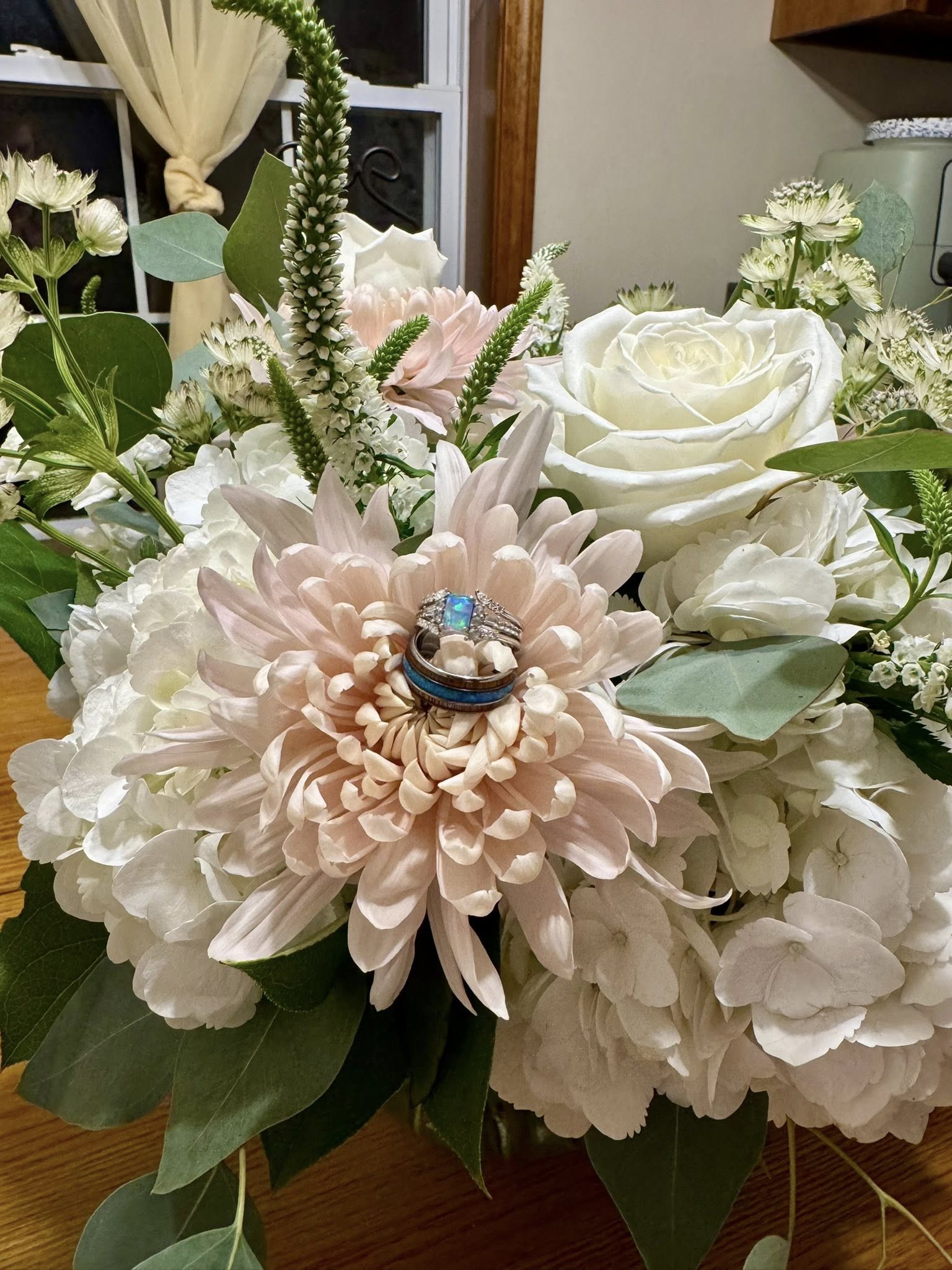 Wedding bouquet with rings resting on a dahlia